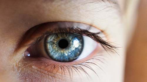 contact lens person opening his right eye with blue iris eye